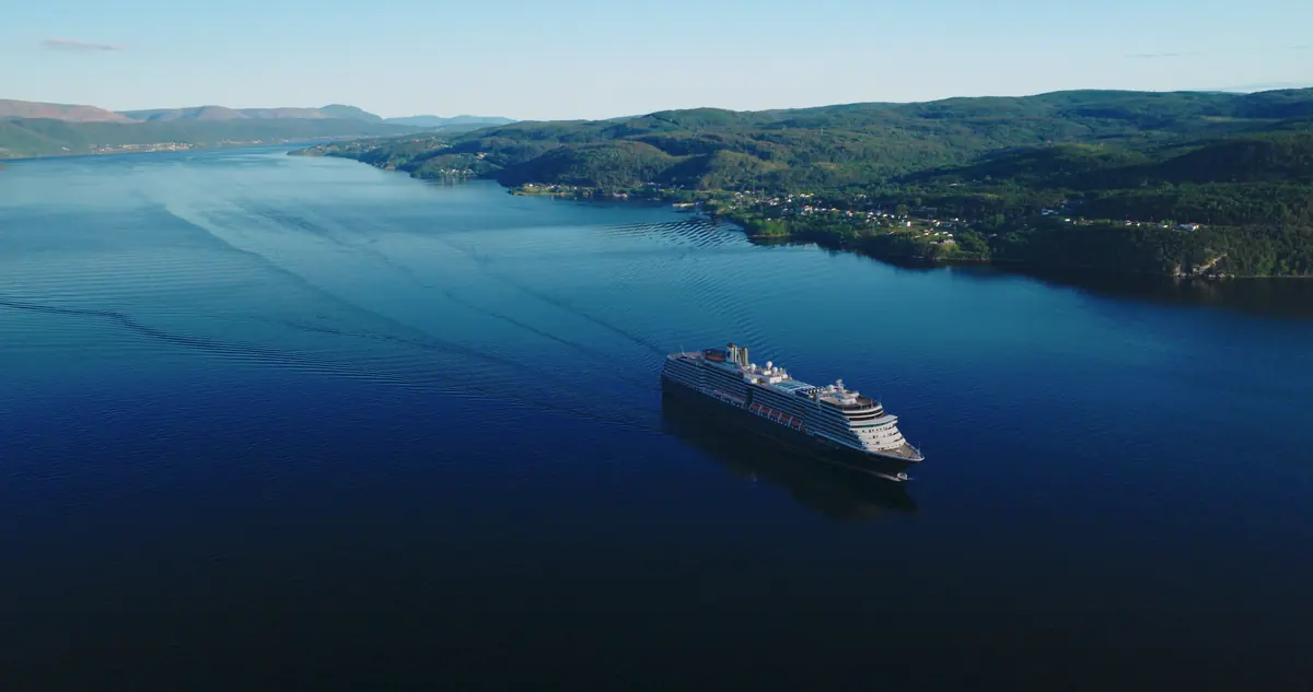 Cruise ship framed by green coastal hills in the Bay of Islands