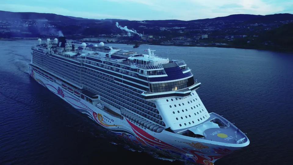 Bow view of Norwegian Joy approaching Corner Brook at dusk