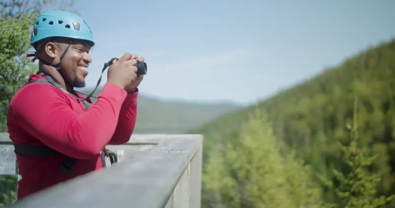Adventurer in safety helmet and harness overlooking Humber Valley